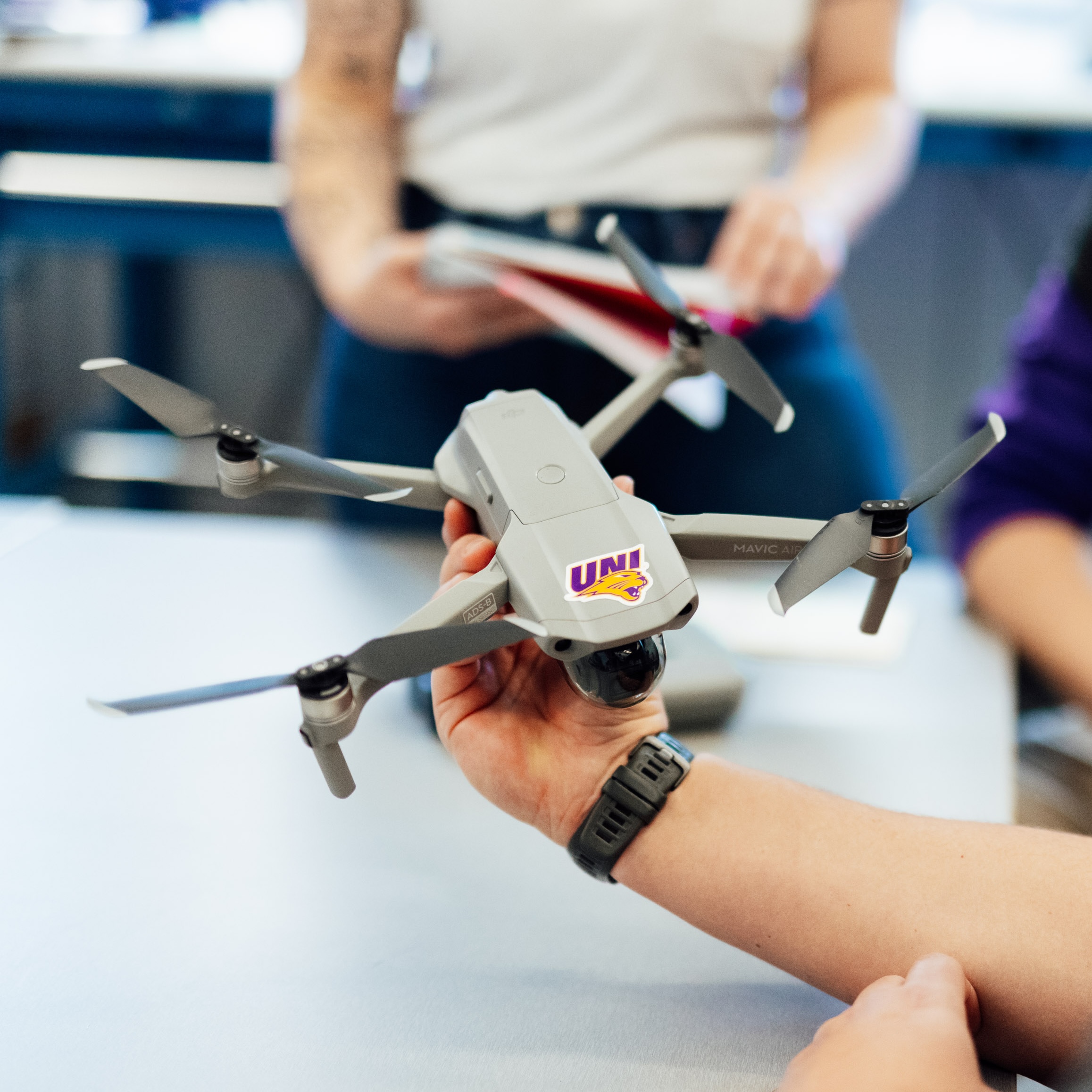 Geography student holding UNI drone