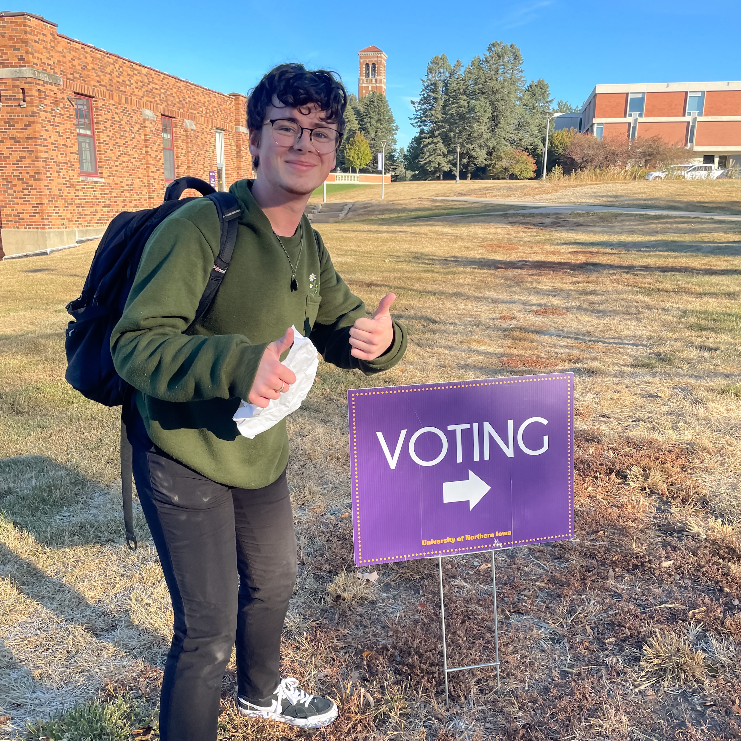 student with voting sign on campus