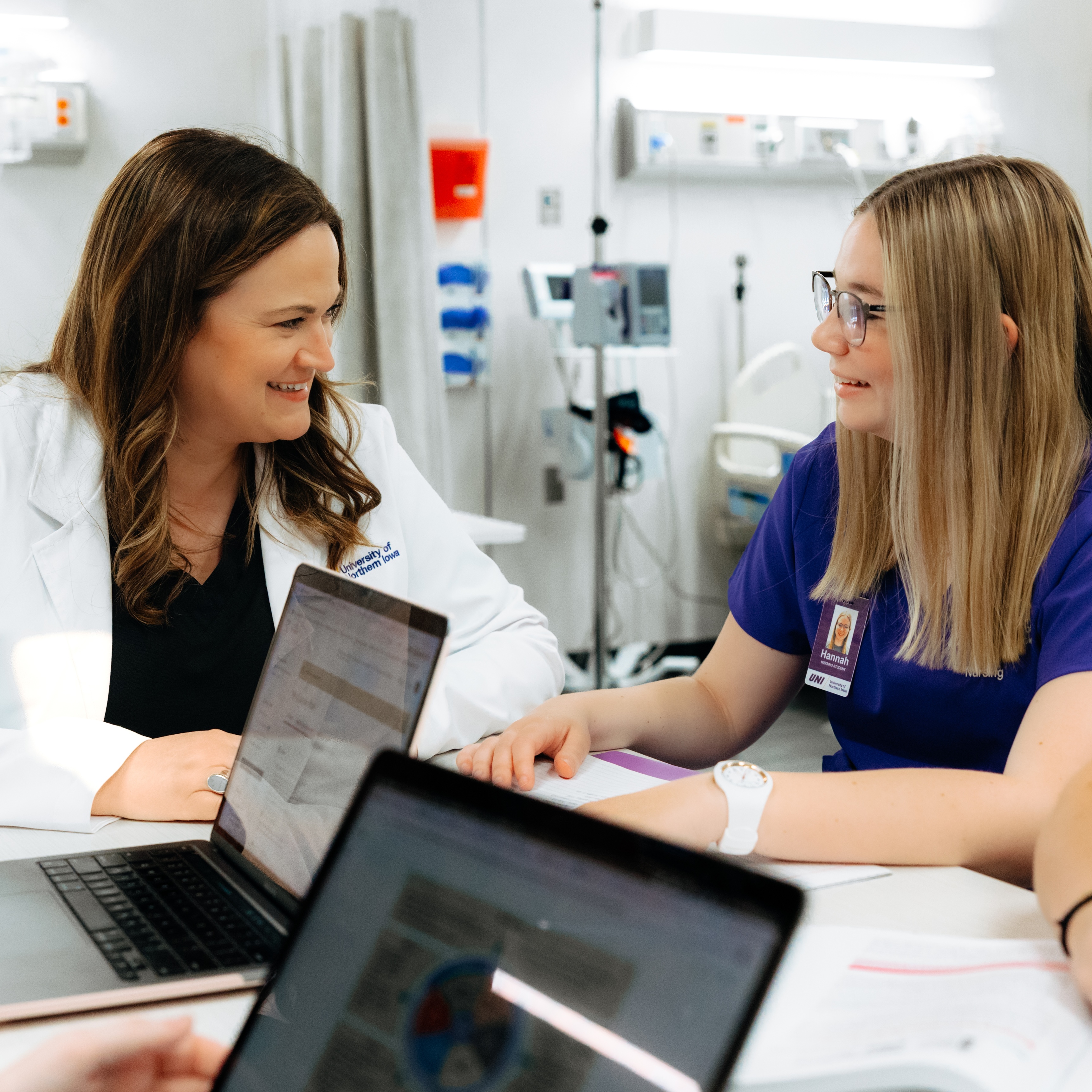 Nursing faculty and student learning at table in integrated classroom