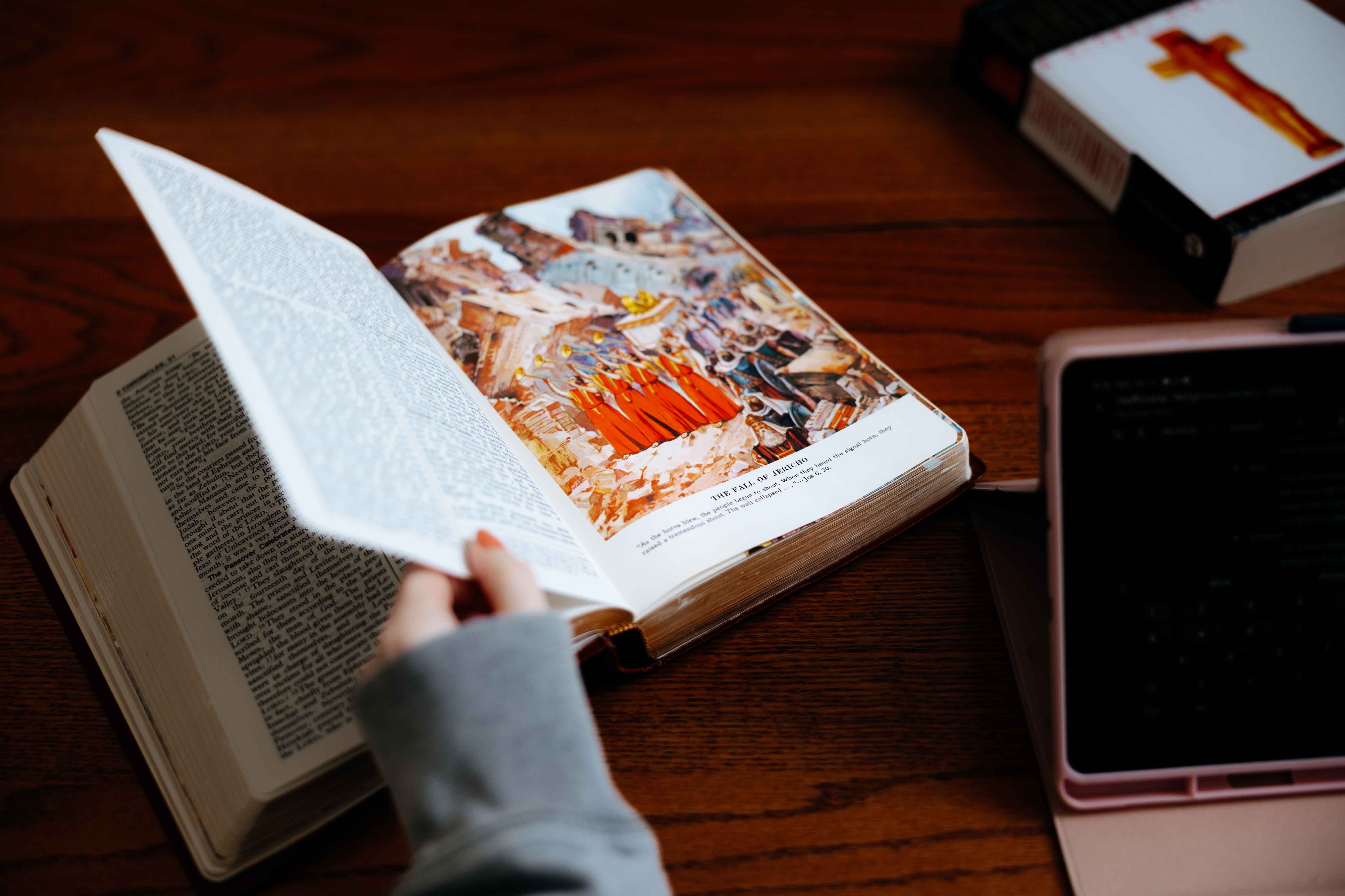 Books on a table with hand turning page