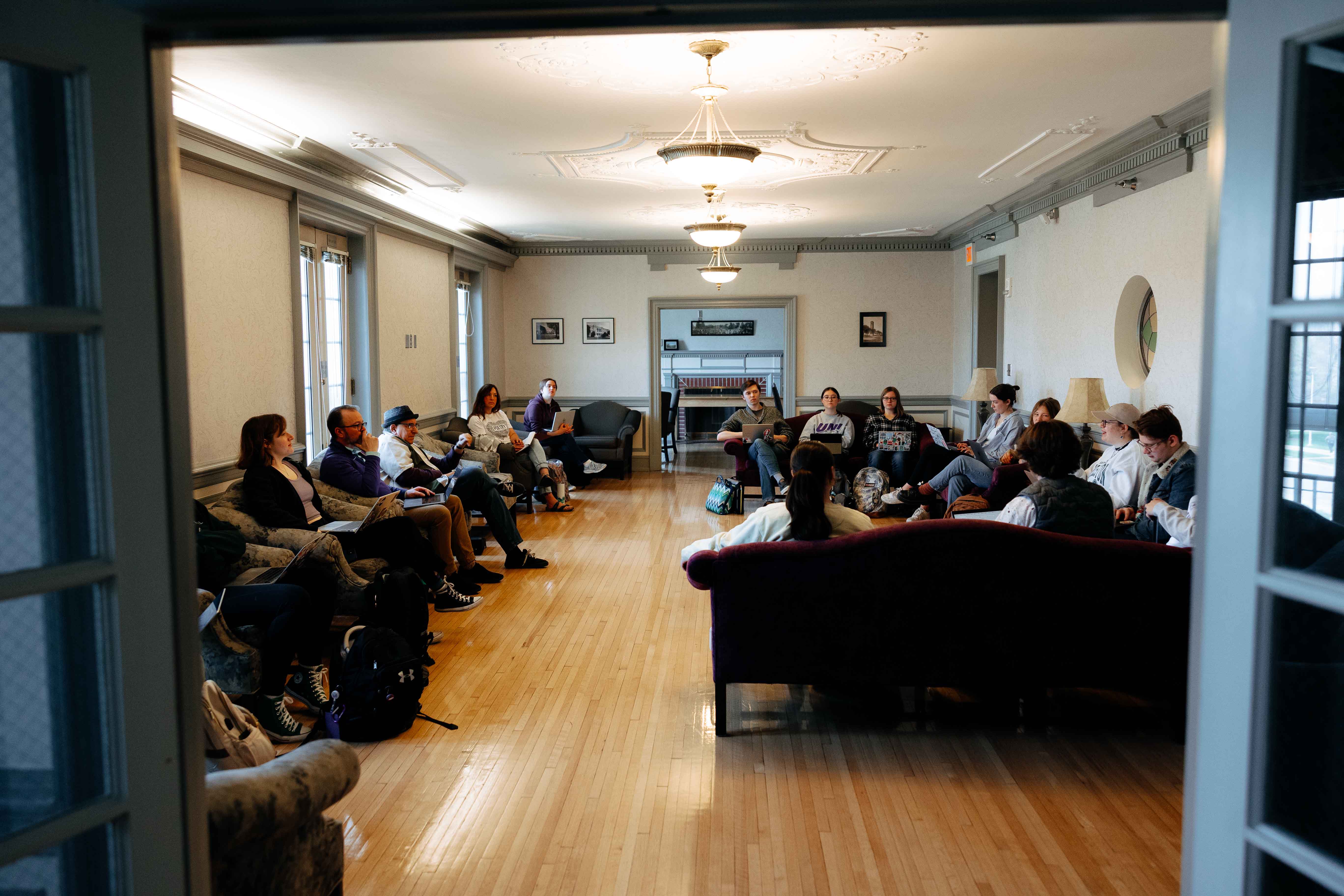Students discussing topics on couches in a room