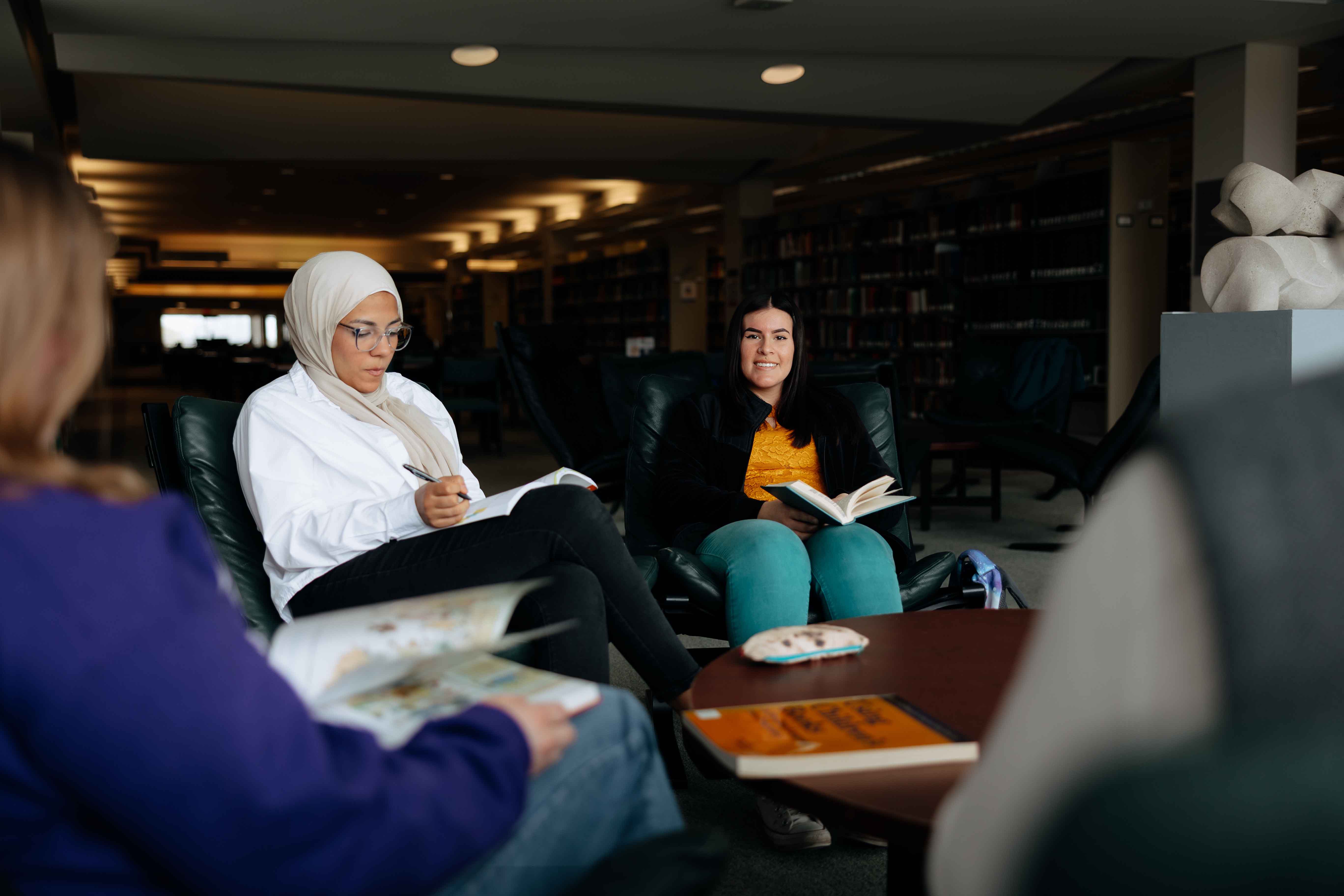 Students working together with books in the library