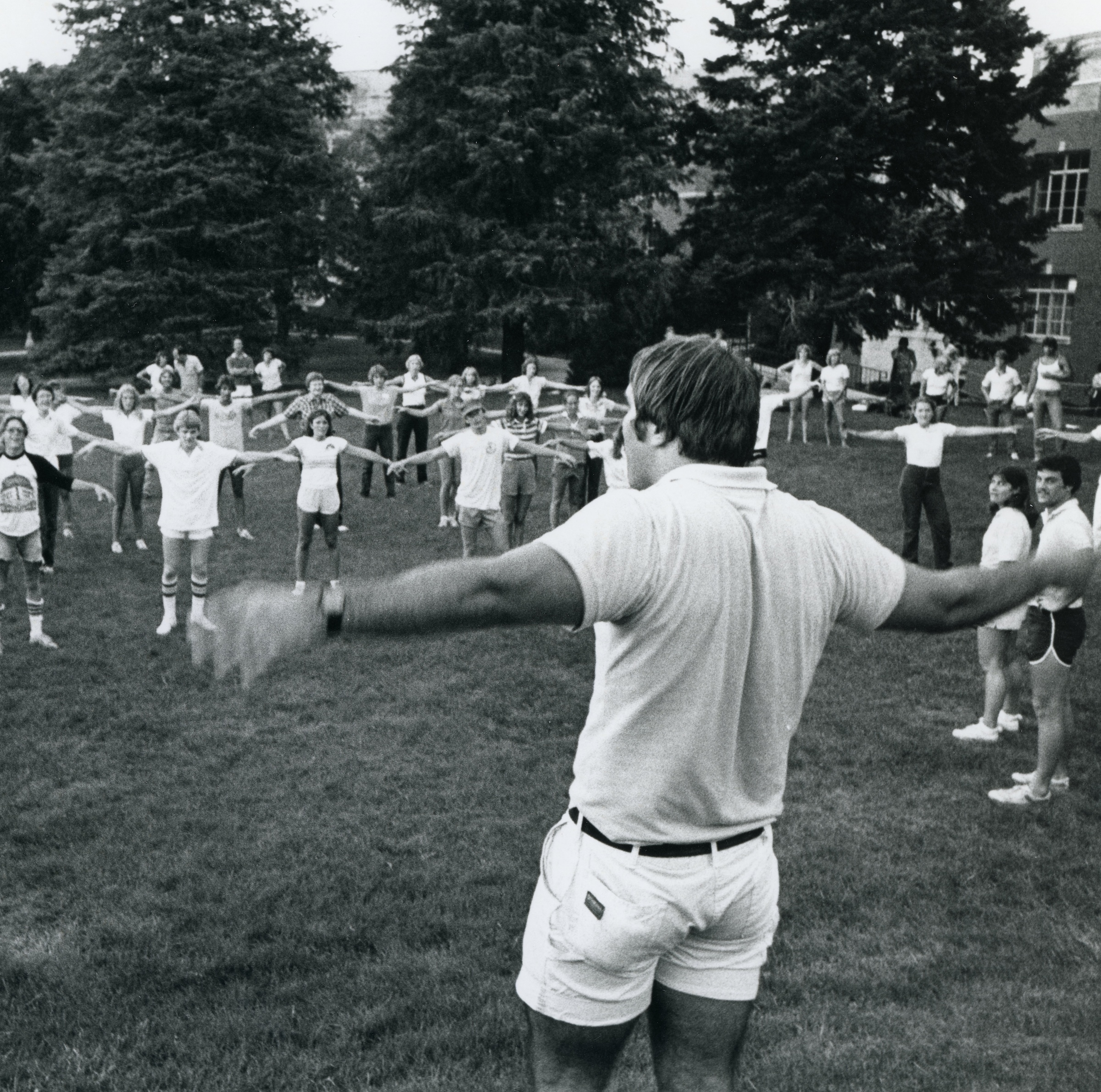 Class being led on campu field in health exercises by faculty “FI0015432,” Cedar Falls, IA, 1981 by UNI Special Collections & University Archives/Fortepan IA