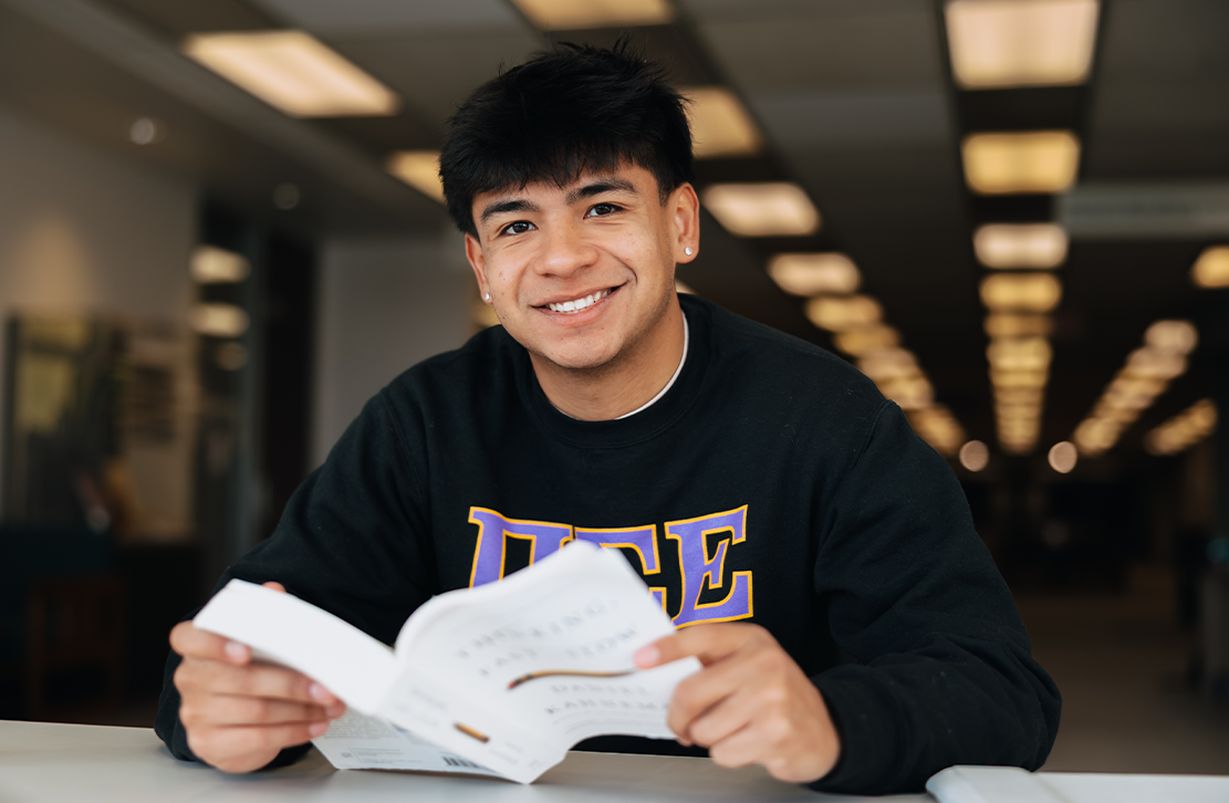 Student reading a book in the library  